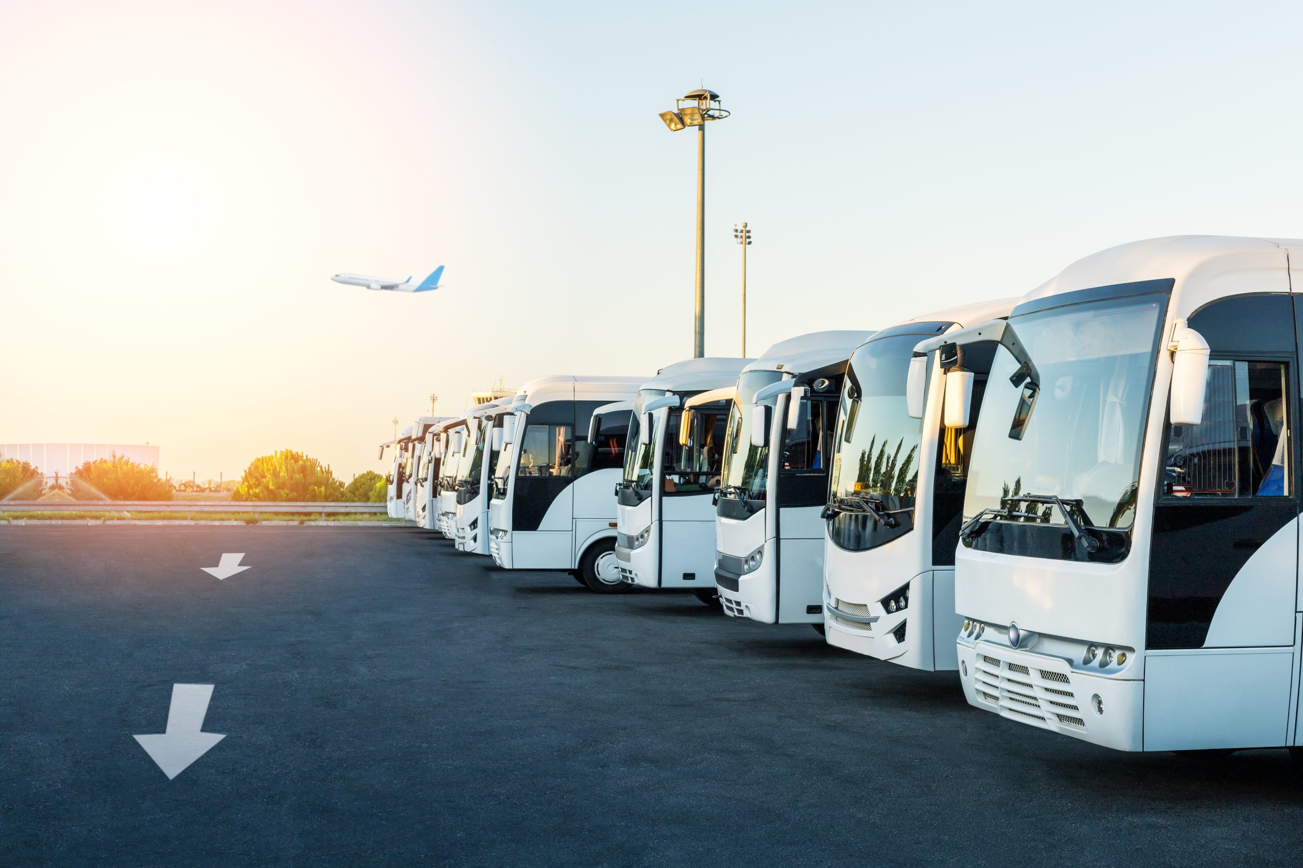 Buses at the parking lot of the airport at sunrise. Holiday, travel, tourism and vacation concept.